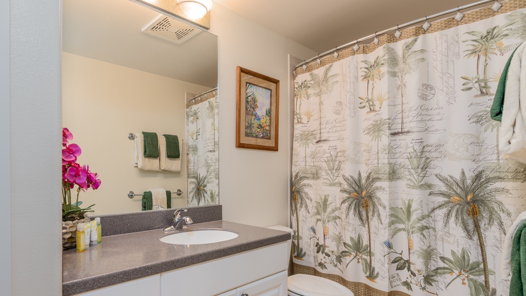 Subtle palm trees in the guest bathroom with a shower located downstairs.