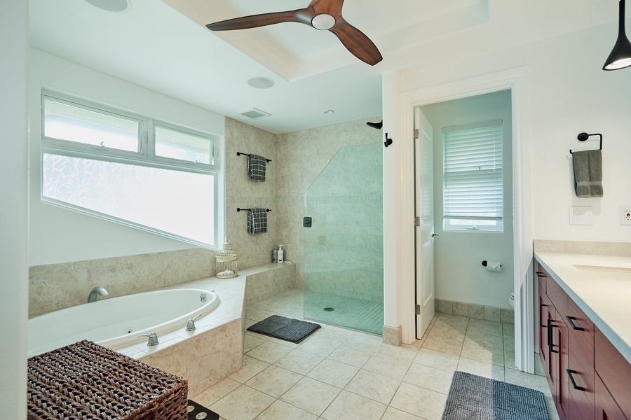 Soak in your private spa-like bathroom featuring a luxurious soaking tub, spacious glass shower, and elegant stone finishes for pure relaxation.