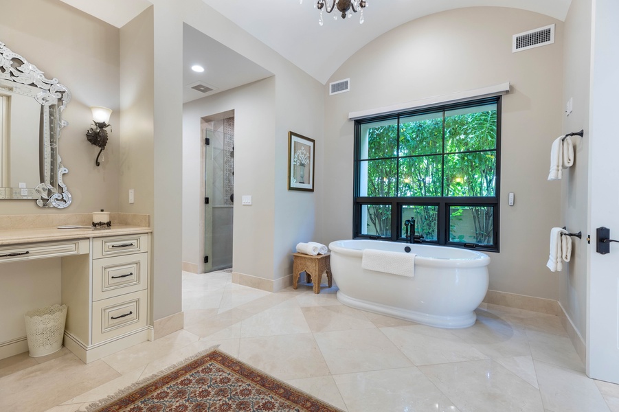 Large bathroom with a freestanding tub, glass-enclosed shower, and scenic window views.