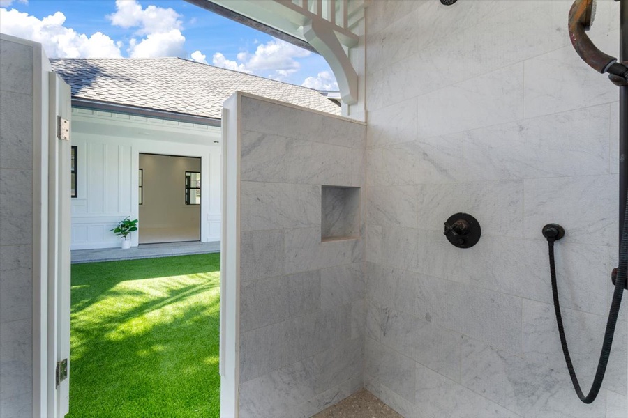 Outdoor shower surrounded by privacy walls, perfect after beach or pool time.
