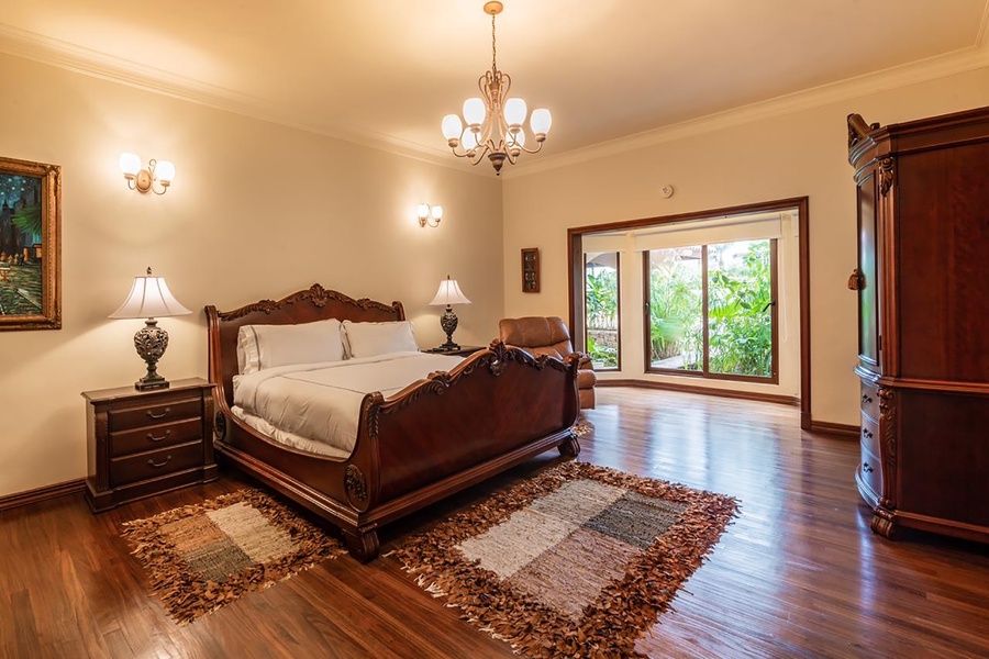 Relax in the second guest bedroom with comfortable bed and garden view through the large windows.