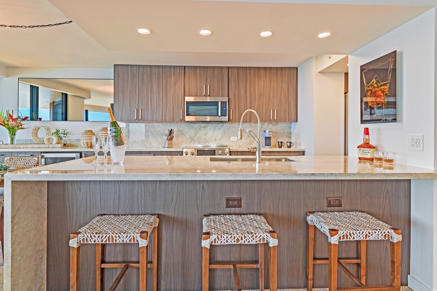 This sleek kitchen island with barstool seating offers a great spot to enjoy casual meals or conversations while cooking.