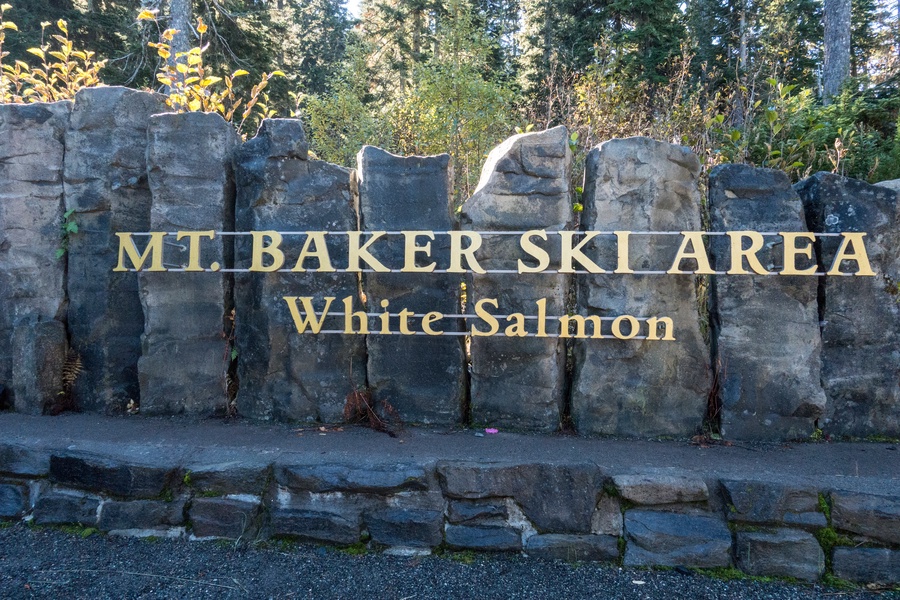 Mt Baker Ski Area entrance sign welcomes visitors to the scenic White Salmon location surrounded by evergreen forests.