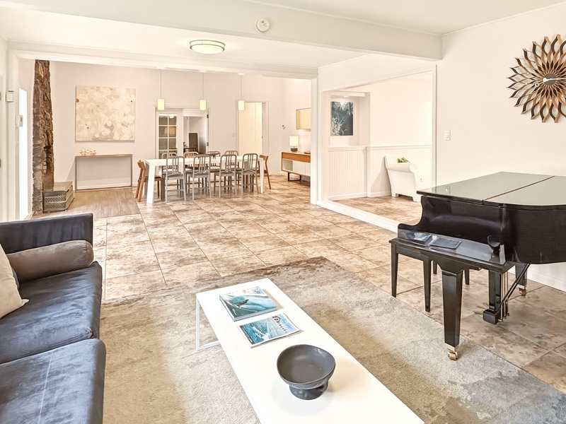 Unwind in your spacious living room with elegant piano, flowing into the bright dining area where memorable meals await.