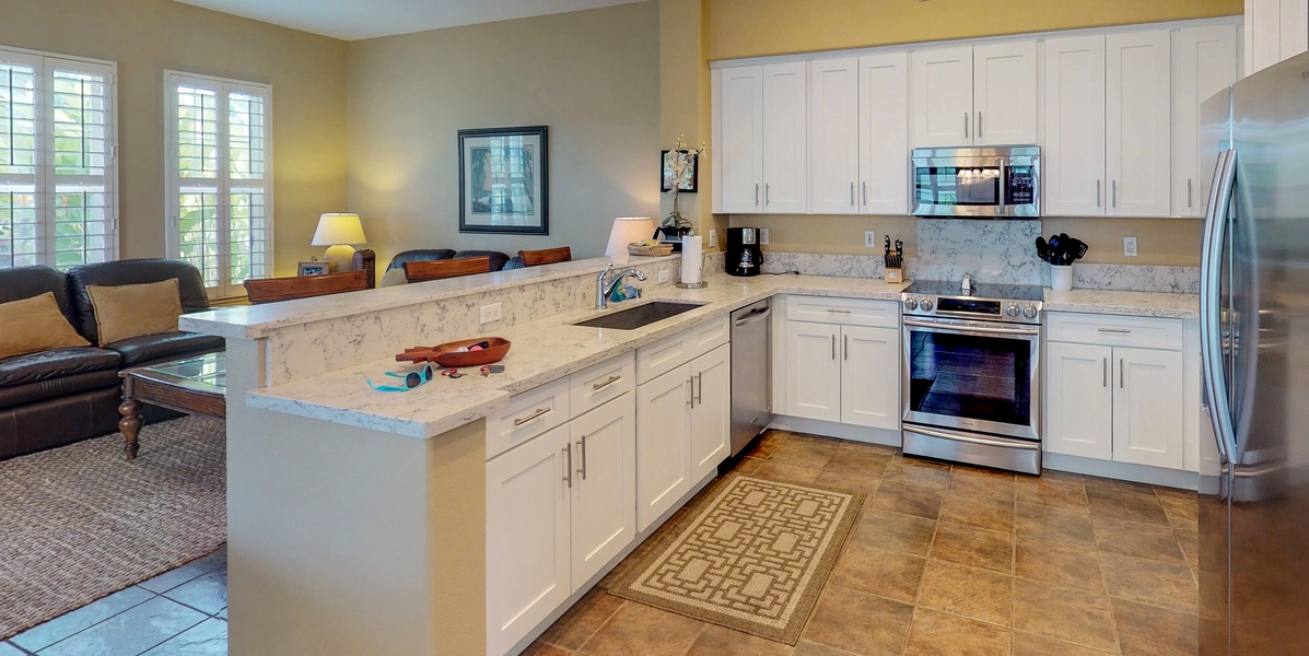The bright kitchen features many amenities including stainless steel appliances.