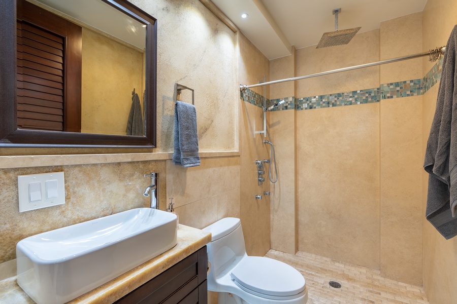 A bathroom with a walk-in shower is just around the corner.