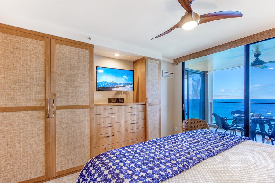 Ocean views await in Mahana 1119’s plush primary suite with lanai access and a flat screen TV.