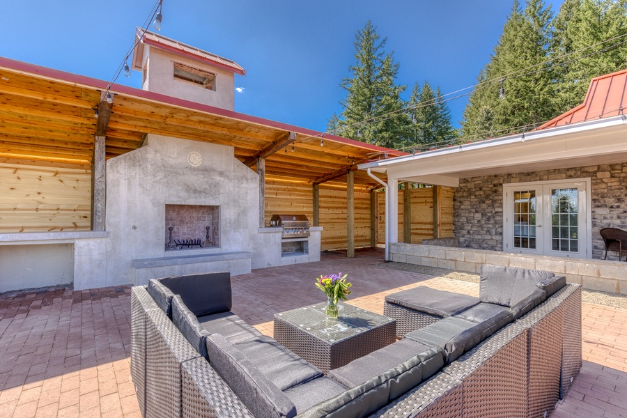 Expansive outdoor living with fireplace, grill, lounging area for the perfect vacation vibe
