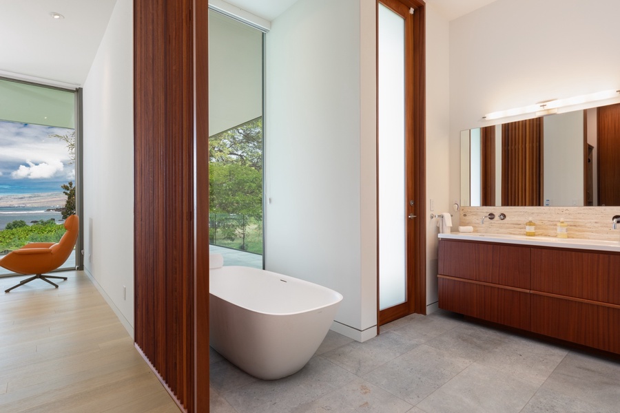 Indulge in this primary bathroom featuring a soaker tub and elegant finishes.