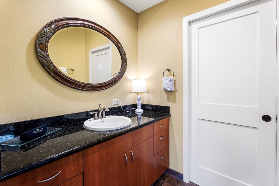 Stylish powder room with a granite countertop and modern lighting for added convenience.