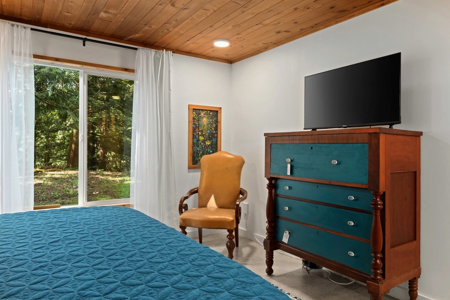 Wake up to tree-filled views from this cozy bedroom with a splash of Pacific Northwest color.