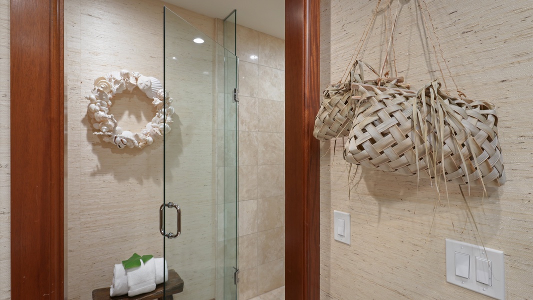 Spa-style walk-in shower with glass doors and coastal accents.