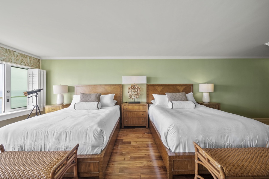 Cozy double twin beds with hardwood floors, soft lighting, and inviting decor—perfect for a restful night by the ocean.