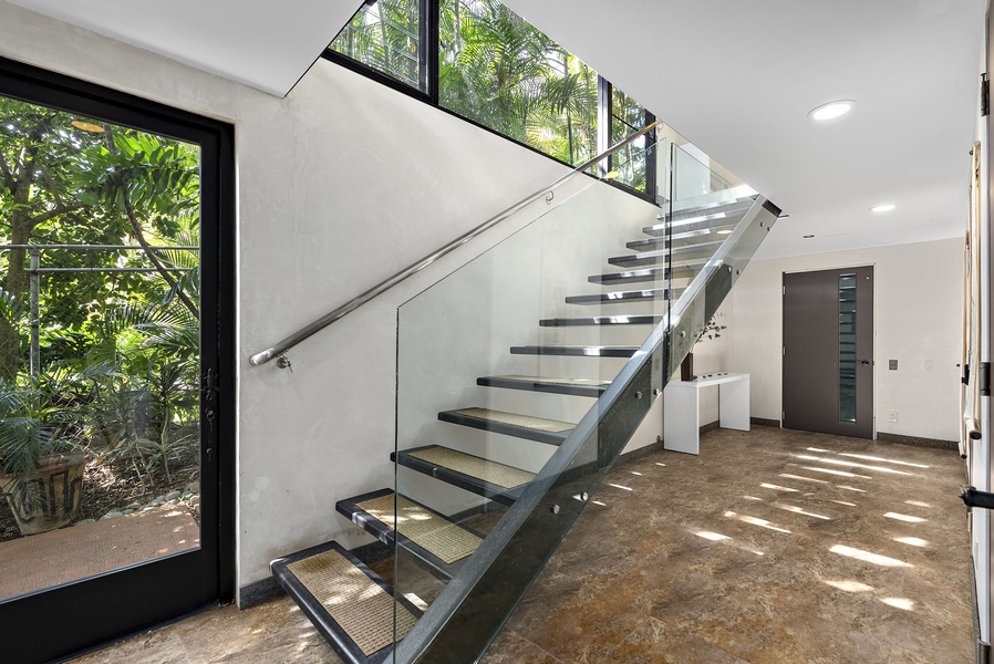 Floating glass staircase enhances the home's contemporary architectural design.