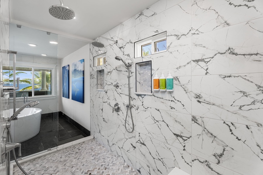 Polished stone tiles and dual shower heads enhance the spa-like experience.