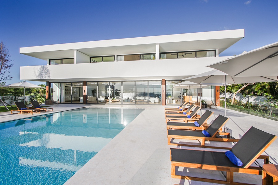 Modern villa exterior with a spacious pool deck and sleek design.