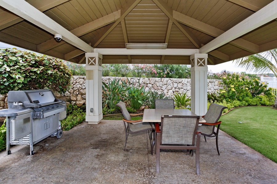 The cabana with a BBQ grill and seating area.