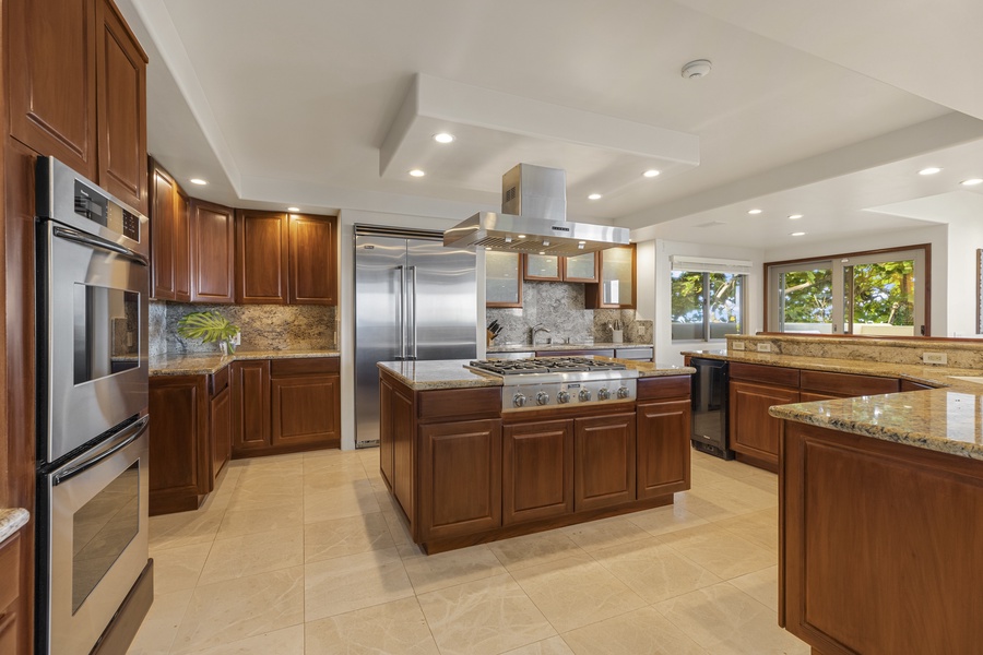 Spacious kitchen with ample breakfast bar seating, center island, and stainless steel appliances
