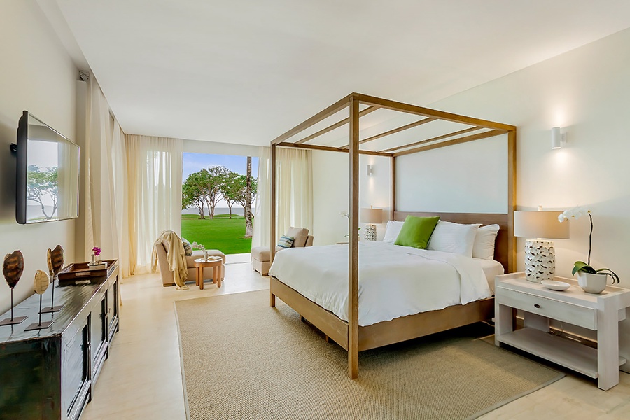 The lower-level secondary suite features four-poster king-sized bed and access to private patio.