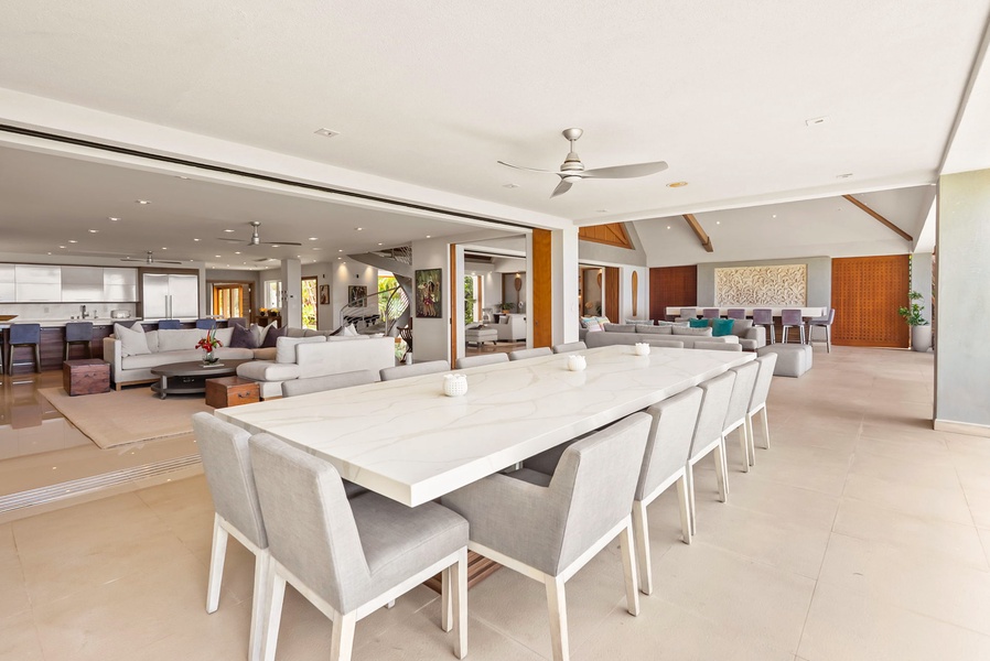 Your open-concept gathering space flows seamlessly from dining to lounge, inviting you to entertain under soaring ceilings cooled by ceiling fans and brightened by natural light.