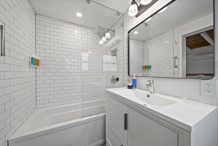 Crisp, newly updated shower with subway tile and clean finishes, offering a spa-like feel for guests.