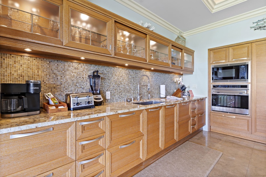 Sleek and stylish, the kitchen at Wailea Hoolei 93-3 features granite, custom cabinetry, and luxe appliances.