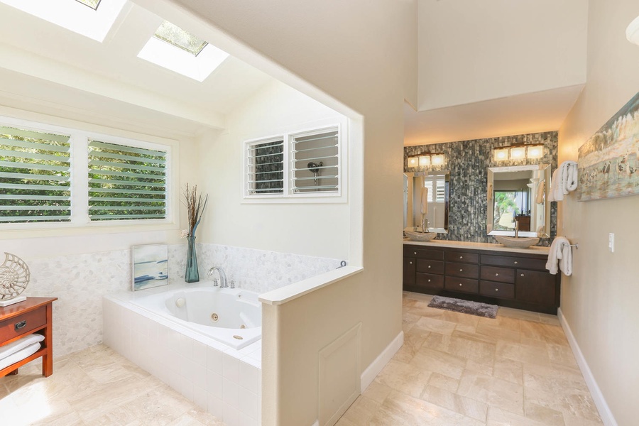 Soaking tub in primary bath with skylight