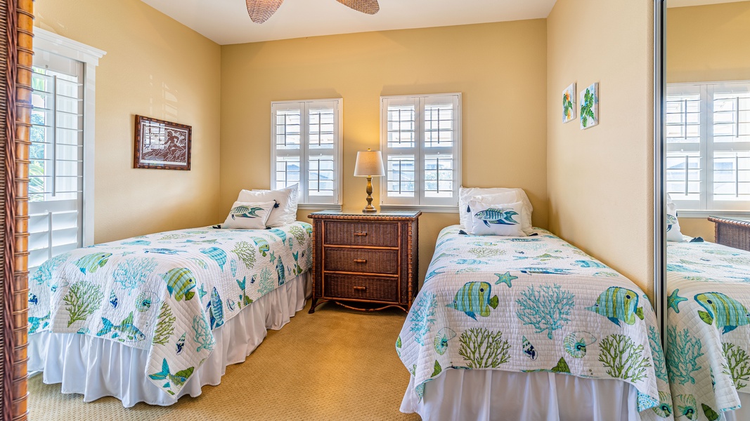 The third guest bedroom with two beds, ceiling fan and soft lighting.