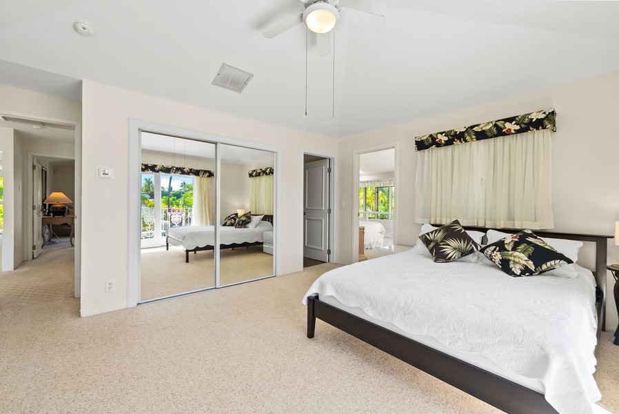 Bright guest suite featuring a mirrored closet and large windows for a light and airy feel.