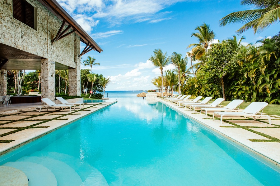 Luxurious pool with ample sun loungers and ocean view.