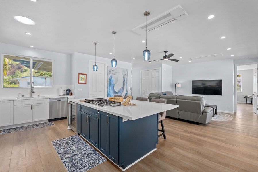 Upper-level kitchen with bold cabinetry, stainless steel appliances, and pendant lighting.