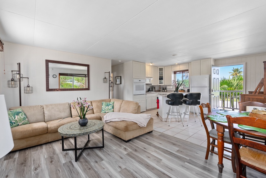 Cozy Ohana Island Retreat's open living room with coastal charm and sunlight-filled windows.