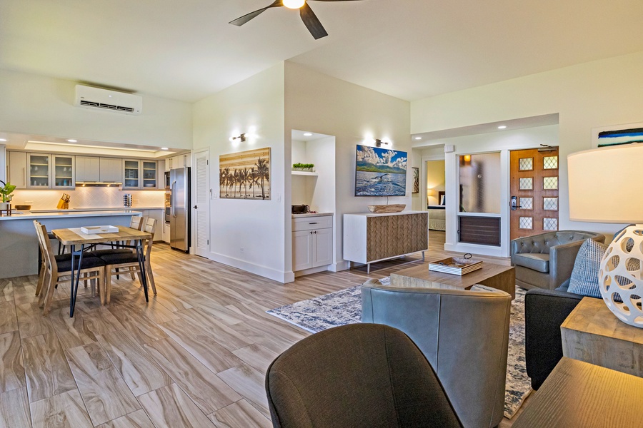 The open-concept living area provides a seamless flow between the kitchen, dining, and entry spaces, with modern finishes and warm natural lighting