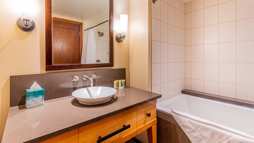 The second guest bathroom features a shower- tub combo.