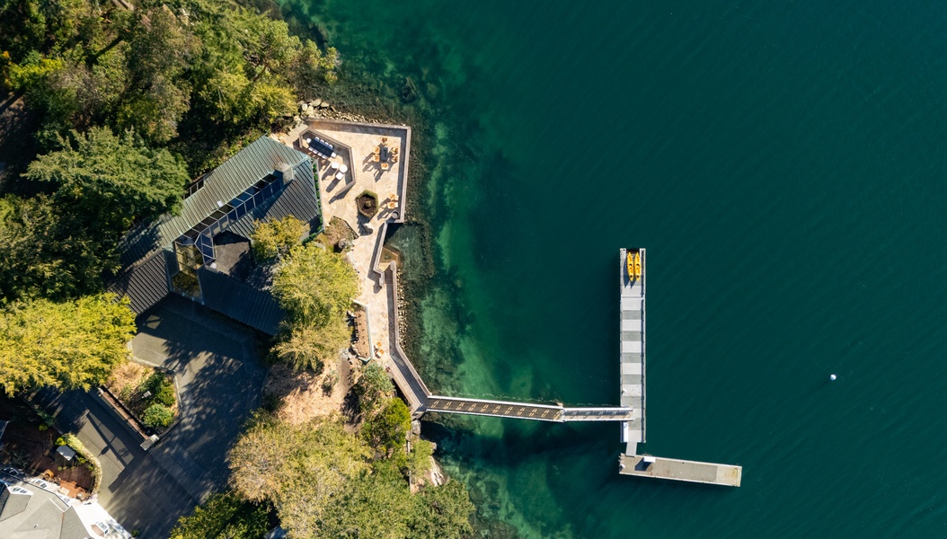 Stunning lakefront property with private dock and waterside terrace overlooking pristine turquoise waters.