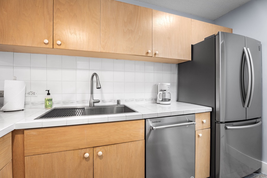 Kitchen area with stainless steel sink and plenty of storage options.