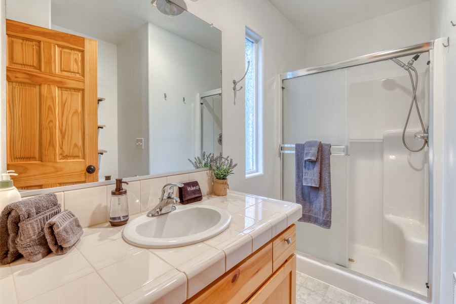The ensuite bath has a single vanity and walk-in shower