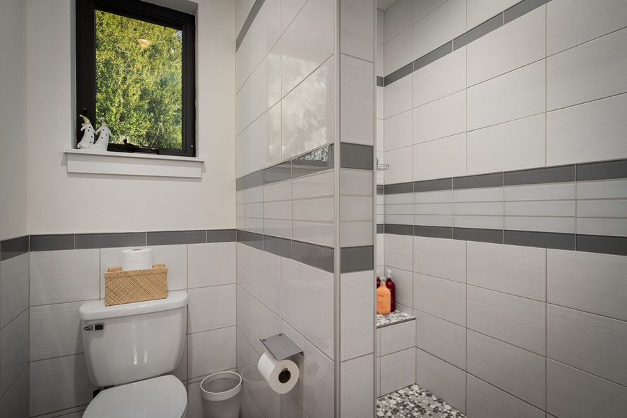 Step into your private sanctuary with modern tiled walls and a refreshing walk-in shower, perfectly designed for unwinding after your adventures.