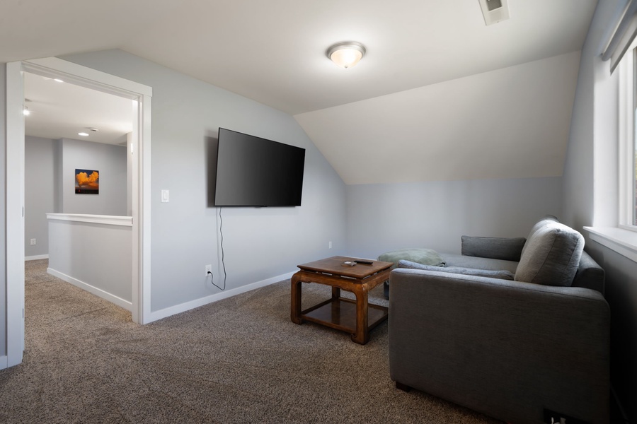 Natural light fills the inviting upstairs sitting area, creating a peaceful spot to unwind after a day exploring the coast.