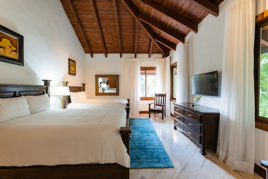 Relax in this charming guest bedroom with double beds and vaulted wooden ceiling.