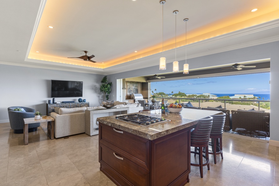 The open-concept kitchen island serves as a central hub for both meal preparation and socializing, seamlessly connecting to the spacious living area and outdoor views.