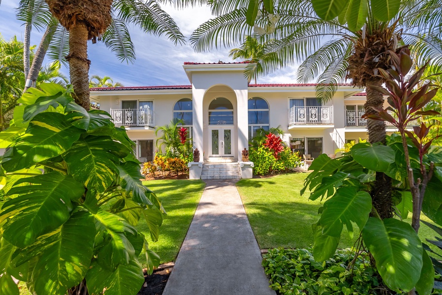 Picturesque entrance pathway lined with tropical plants, welcoming you to your private villa oasis.