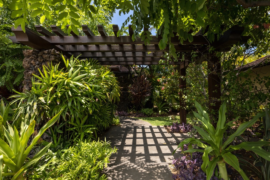 Exterior entryway leading to front door with lush tropical landscaping.
