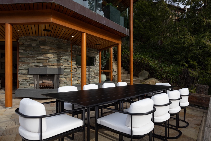 Gather around this stunning outdoor dining table where memorable meals unfold against a backdrop of natural stone and forest views.