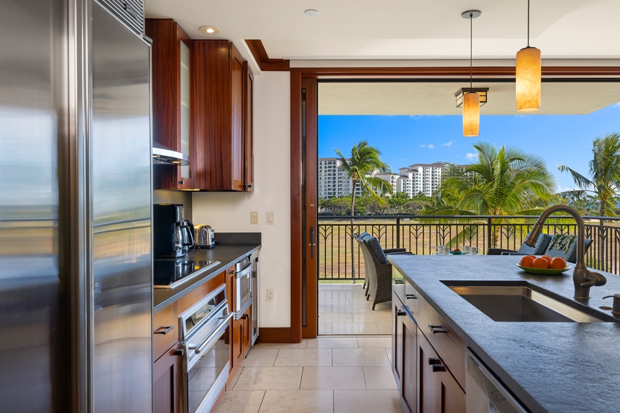 Your gourmet kitchen opens to tropical views through sliding doors, where granite counters and premium appliances meet warm island breezes and swaying palms.