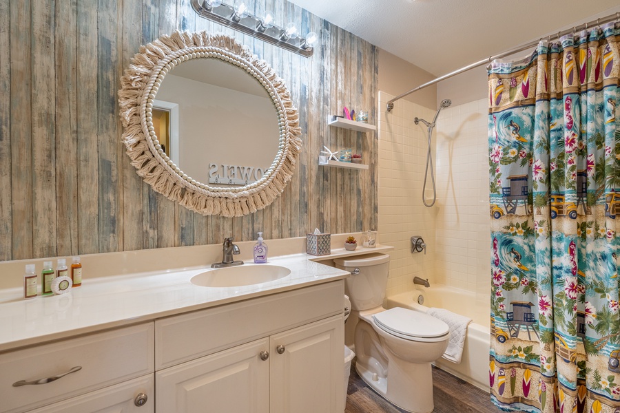 Refresh in your stylish bathroom featuring rustic wood-inspired walls, tropical shower curtain, and thoughtful touches that make your stay feel like home.