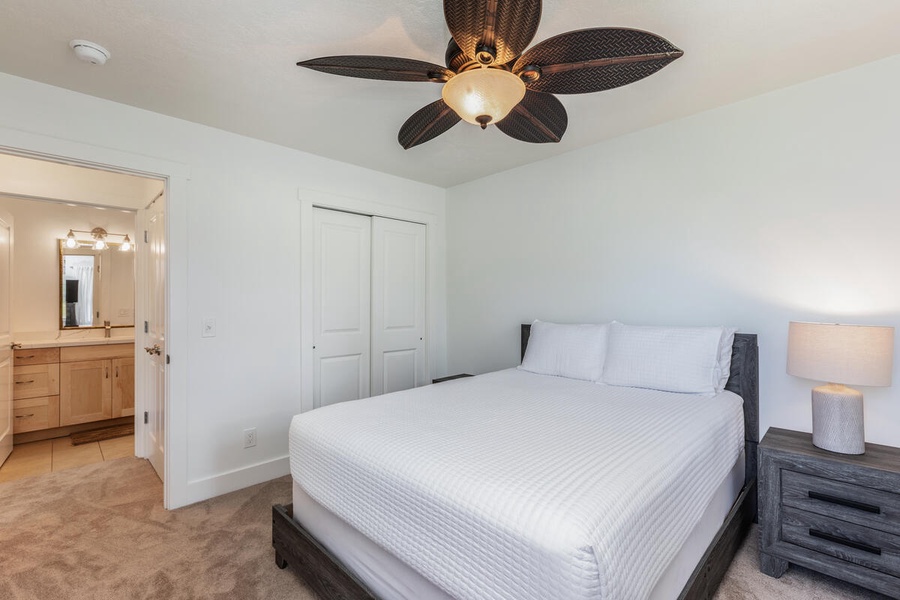 Queen bedroom with warm tones and ceiling fan for cool, comfortable evenings.