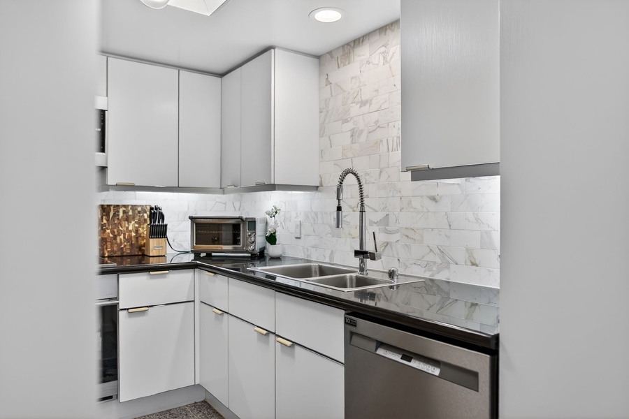 Cook comfortably in this modern kitchen with marble backsplash and stainless appliances.