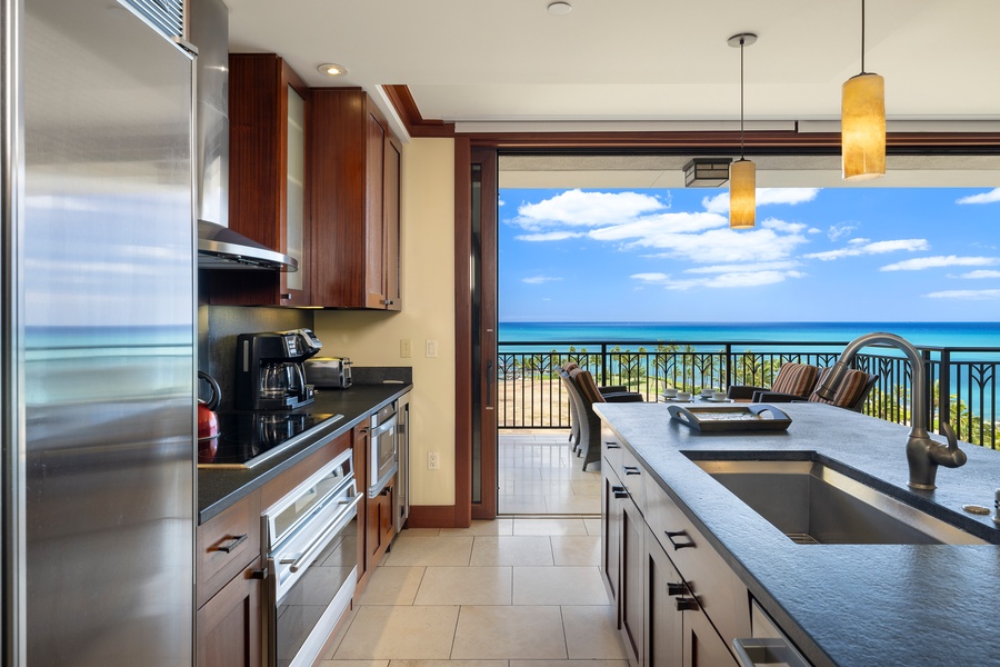 Your gourmet kitchen opens to breathtaking ocean views, where cooking becomes pure joy with azure waters stretching endlessly beyond your private balcony.