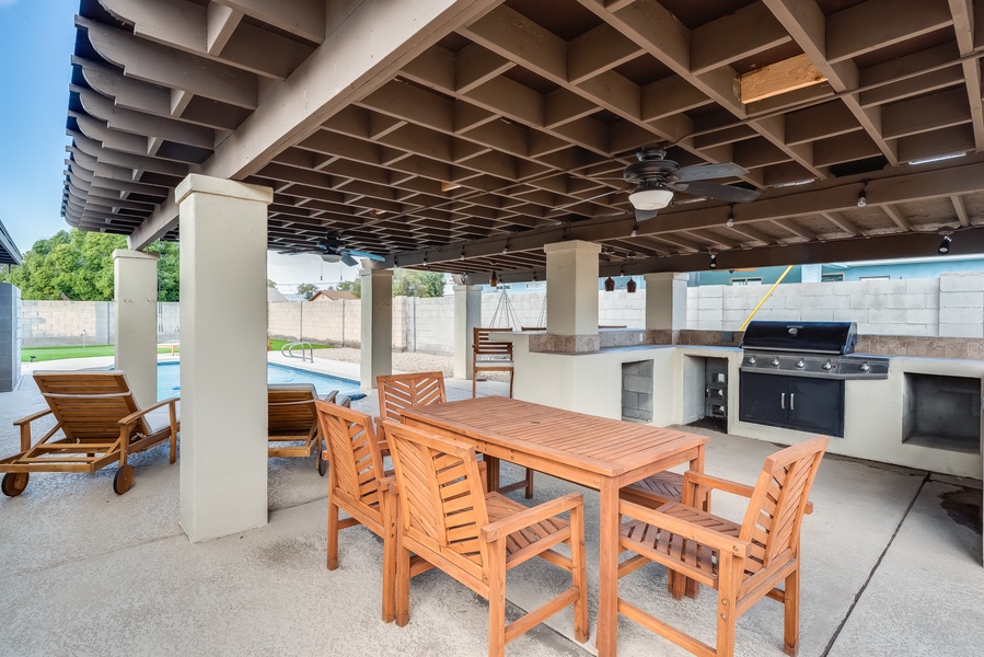 Beautiful covered space with bbq, dining table and pool nearby